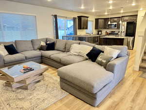 Living area with light wood-type flooring, recessed lighting, and a textured ceiling