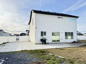 Rear view of property featuring a fenced backyard, a patio area, and a gate