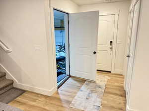 Entryway with light wood-style floors and stairs