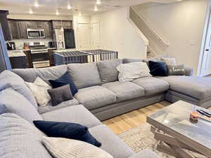 Living area featuring light wood-style flooring, a textured ceiling, and recessed lighting