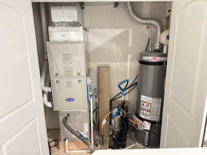 Utility room featuring heating unit and water heater