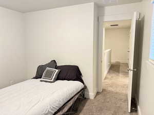 Bedroom with light carpet and baseboards