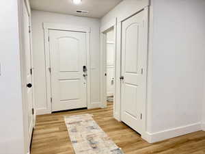 Entryway with a textured ceiling and wood finished floors