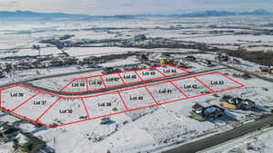 Snowy aerial view with property boundaries highlighted and a mountain view