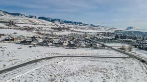 Snowy aerial view featuring a mountain view and a residential view