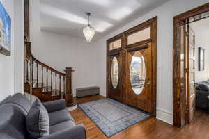 Foyer with hardwood / wood-style floors and a chandelier