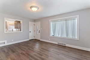 Entryway featuring dark wood finished floors and a textured ceiling