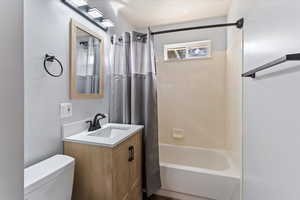 Bathroom featuring vanity and shower / bathtub combination with curtain