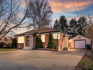 Ranch-style house featuring a garage, concrete driveway, an outdoor structure, and brick siding