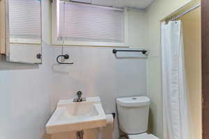 Bathroom with toilet and a shower with curtain