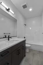 Bathroom with vanity, shower / bath combination, light tile patterned floors, and recessed lighting