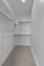 Walk in closet with light carpet
