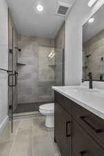 Bathroom with vanity, a stall shower, light tile patterned floors, and recessed lighting
