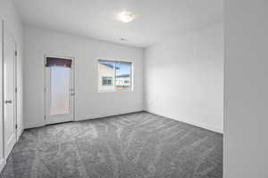 Empty room featuring light carpet and baseboards