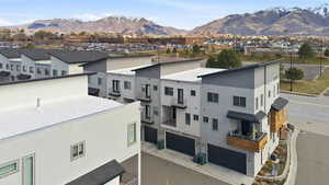 View of property with a mountain view, a garage, and a residential view