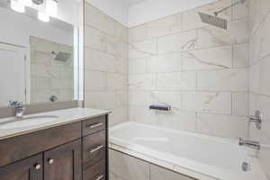 Bathroom featuring vanity and tiled shower / bath