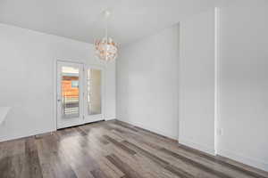 Unfurnished dining area featuring hanging lights and wood finished floors
