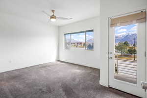 Carpeted empty room with a mountain view and ceiling fan