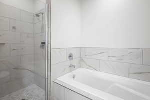 Full bathroom with a marble finish shower and a garden tub
