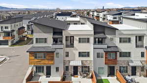 Back of property with stone siding, stucco siding, and a residential view