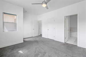 Unfurnished bedroom with light carpet, connected bathroom, and a ceiling fan