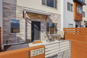 Doorway to property with stone siding and stucco siding