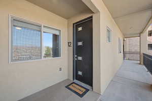 Doorway to property featuring stucco siding