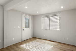 Foyer entrance featuring light wood finished floors, recessed lighting, and a textured ceiling