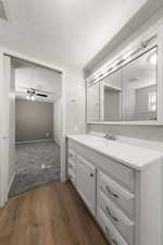 Bathroom with vanity, dark wood-type flooring, and a textured ceiling