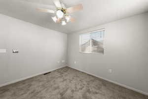 Carpeted spare room featuring a textured ceiling and ceiling fan