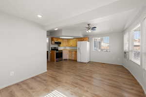 Kitchen featuring stainless steel appliances, light countertops, light wood-style flooring, ceiling fan, and recessed lighting