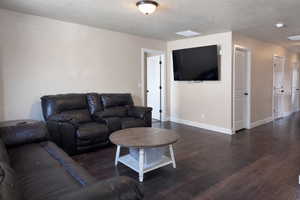 Living room featuring a textured ceiling and hardwood / wood-style flooring
