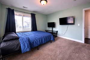 Bedroom featuring carpet floors and baseboards