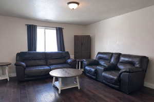 Living room with hardwood / wood-style floors and a textured ceiling