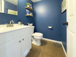 Bathroom with vanity and dark tile patterned floors