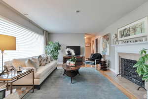 Living room featuring a fireplace with flush hearth and wood finished floors