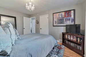 Bedroom featuring suspended lighting and light wood-type flooring