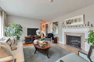 Living room featuring light wood-style floors and a tiled fireplace