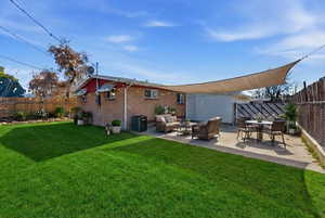 Rear view of house featuring an outdoor living / dining area, a fenced backyard, a patio, and brick siding