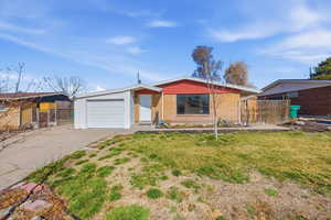 View of front of home with concrete driveway, an attached garage