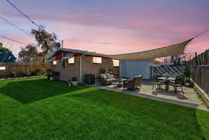 Back of property with an outdoor living / dining area, a fenced backyard, a patio area, and brick siding
