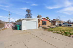 Single level  home featuring concrete driveway and an attached garage