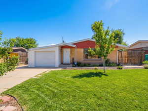 View of front of house featuring concrete driveway, and garage, virtually enhanced