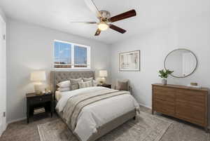Carpeted bedroom featuring ceiling fan and baseboards