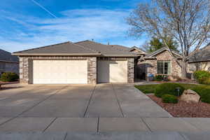 Ranch-style home with a garage, brick siding, concrete driveway, and a tile roof
