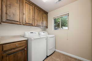 Laundry room featuring cabinet space and independent washer and dryer