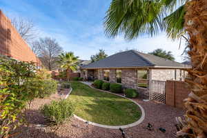 Back of house featuring a fenced backyard and brick siding