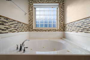 Full bathroom with a tub with jets