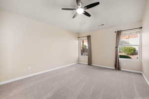 Empty room with light colored carpet and ceiling fan