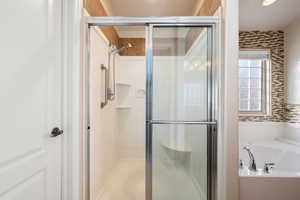 Bathroom featuring a shower stall and a bath